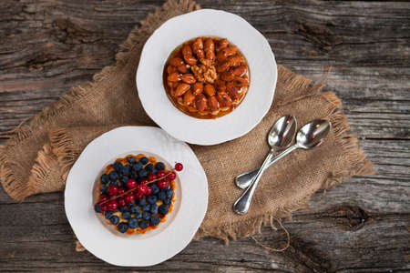 Almonds tart and Walnut tartlets with custard and berries on wooden table background.の写真素材