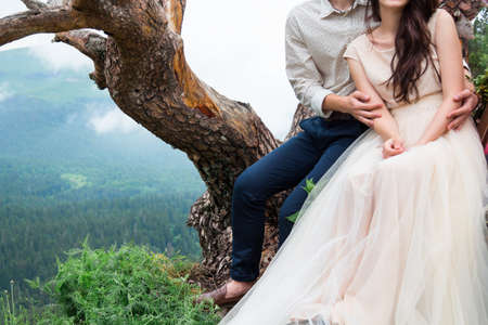 Happy young couple in love outdoors. Gorgeous bride and stylish groom on top, fine art wedding couple,  Beautiful mountains view. Love and tender. Wedding inspirationの写真素材