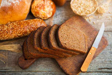Fresh bread and wheat on the wooden table background