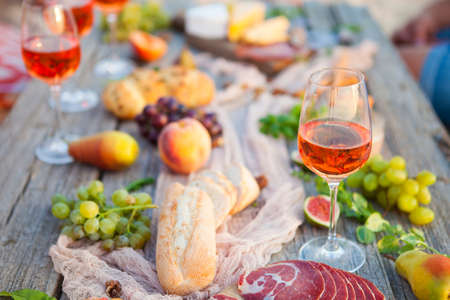 Picnic on the beach at sunset in the style of boho, food and drink conceptionの写真素材