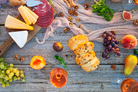 Picnic on the beach at sunset in the style of boho, food and drink conceptionの写真素材