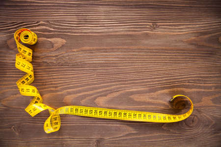 Copyspace frame with sewing tools and accesories on brown wooden background, top viewの写真素材