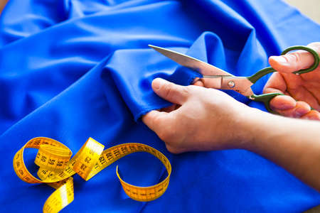 Tailor. Man Hands notch tailor tailor's scissors cloth. Close Up.の写真素材