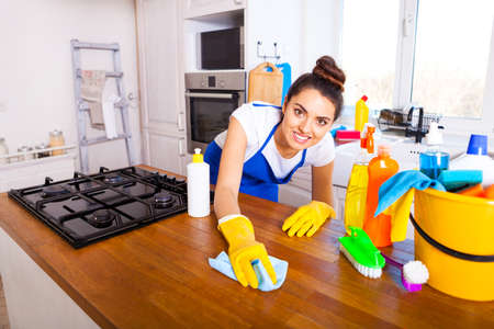 Beautiful young woman makes cleaning the house. Girl cleaning kitchen. Set.の写真素材