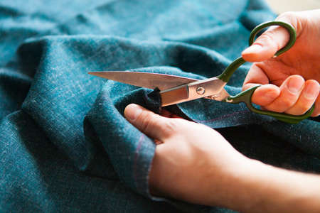Tailor. Man Hands notch tailor tailor's scissors cloth. Close Up.の写真素材