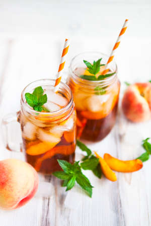 Homemade iced lemonade with ripe  peaches and fresh mint. Fresh peach ice tea in a mason jar. Copy space background.の写真素材