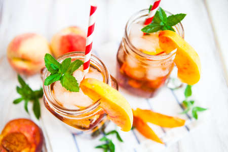 Homemade iced lemonade with ripe  peaches and fresh mint. Fresh peach ice tea in a mason jar. Copy space background.の写真素材