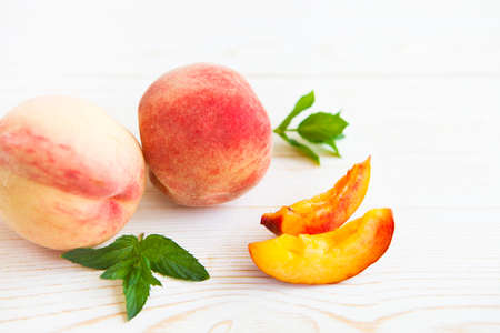 Fresh peaches with mint on wooden white background. Closeupの写真素材