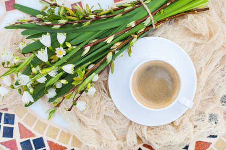 Bouquet White spring bellflowers and coffee cup on table in garden. Spring morning with coffee.の写真素材