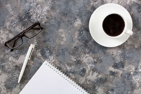 Modern gray work office desk table with laptop, keyboard, smartphone and other business accessories, supplies with cup of coffee. Top view, flat lay.の写真素材