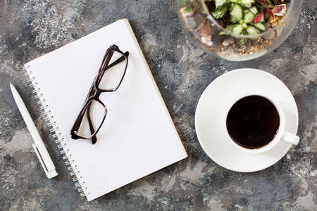 Modern gray work office desk table with laptop, keyboard, smartphone and other business accessories, supplies with cup of coffee. Top view, flat lay.の写真素材