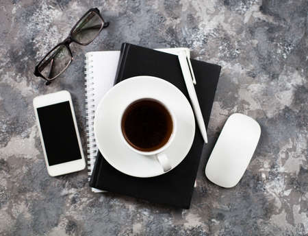 Modern gray work office desk table with laptop, keyboard, smartphone and other business accessories, supplies with cup of coffee. Top view, flat lay.の写真素材