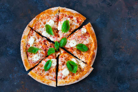 Pizza margarita with tomato sauce, fresh mozzarella, parmesan and basil on the dark rusty backgroundの写真素材