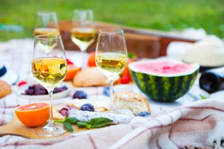 Summer Picnic Basket on the Green Grass. Food and drink concept. Friends Party time