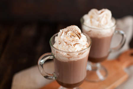 Two glasses with Hot chocolate garnished with whipped cream and cocoa powder.の写真素材