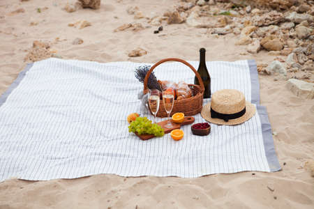 Two glasses of champagne. Summer Picnic on the beach at sunset in the white plaid, food and drink conception.の写真素材