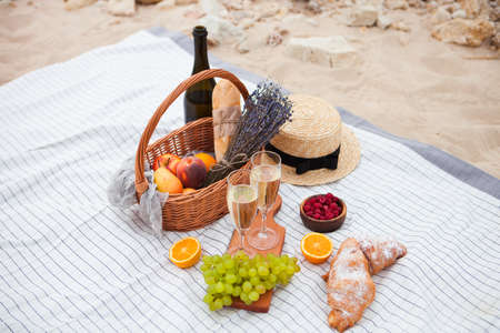 Two glasses of champagne. Summer Picnic on the beach at sunset in the white plaid, food and drink conception.の写真素材