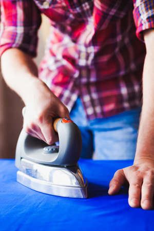 Tailor ironing the fabric. seamstress irons dress in a sewing workshop, close upの写真素材