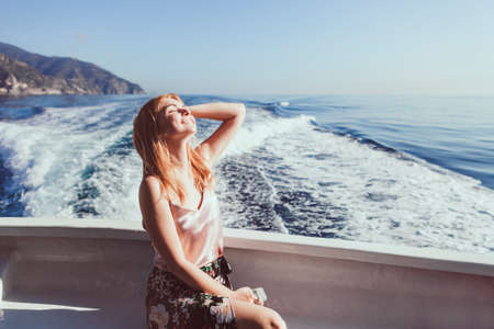 Happy young amazing woman wearing relaxing on the yacht in Cinque Terre, Italy, Ligurian Sea,...