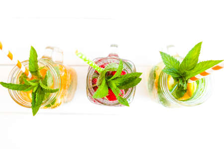 Fresh lemonade with summer fruits and berries on white background