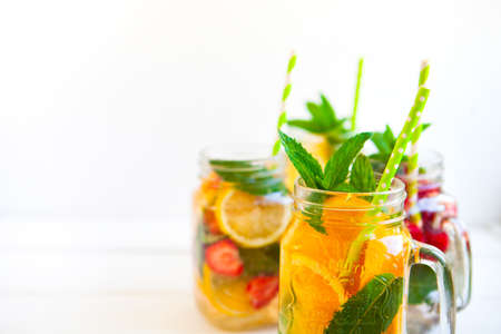 Fresh lemonade with summer fruits and berries on white background
