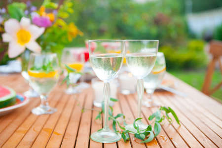 Two glasses of white wine. Family outdoor dinner in the garden in summertime at sunset. Picnic food and drink conceptの写真素材