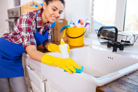 Beautiful young woman makes cleaning the house. Girl cleaning kitchen. Set.の写真素材