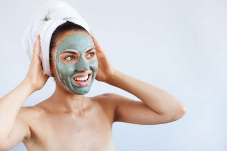 Young beautiful woman in the face mask of therapeutic blue mud.の写真素材