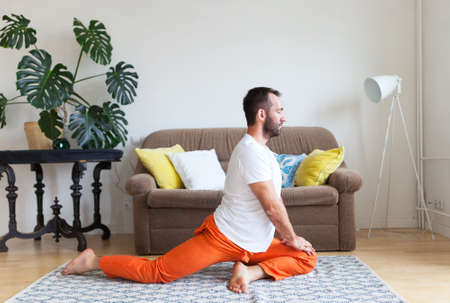 Man practicing yoga and meditation at home. A series of yoga poses. Lifestyle concept.の写真素材