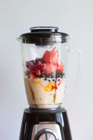A blender filled with fresh whole fruits for making a smoothie or juice. Healthy eating concept. Close Upの写真素材