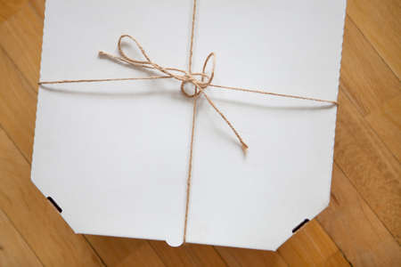 Close up of a white pizza box template on wood background.