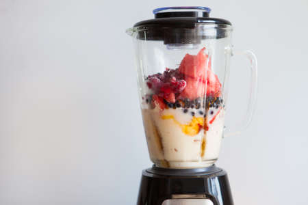 A blender filled with fresh whole fruits for making a smoothie or juice. Healthy eating concept. Close Upの写真素材