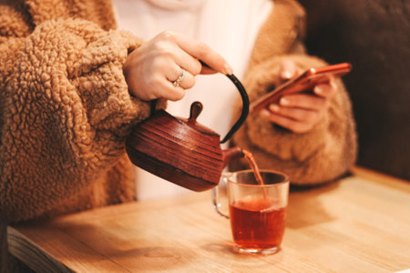 the girl pours tea into a glassの写真素材