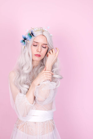 blonde girl in white clothes on a pink backgroundの写真素材