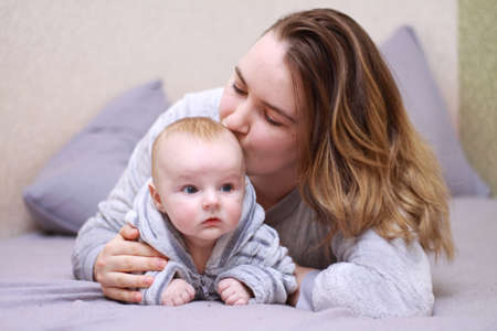 home photos of a young mother with a small child. Newborn boy. Cute, cozy photos with a baby.の写真素材