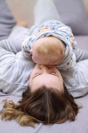 home photos of a young mother with a small child. Newborn boy. Cute, cozy photos with a baby.