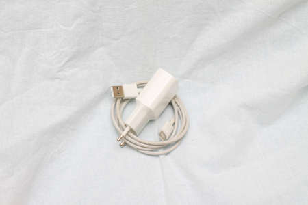 charger for the phone. white wire. Cord. electronics.