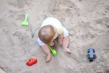little boy playing in the sand. baby plays with sand. Summer rest. Sun, sea, beach, sand. Rest, childhood.の写真素材