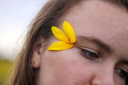 young brunette girl in a field of sunflowers. summer evening. romantic summer.