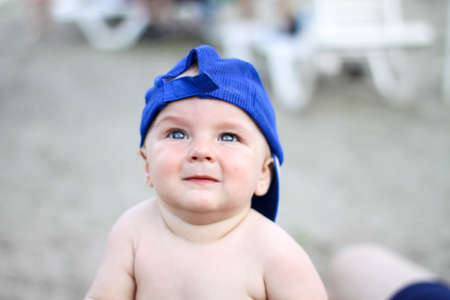 toddler baby close-up in a blue cap. joyful childhood. rest, sea, beach. carelessness.