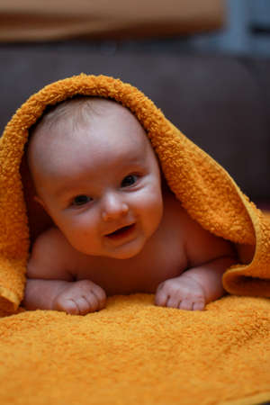 home photo of a small baby. a little newborn baby lies on a towel. little boy boy. cute kid at home.