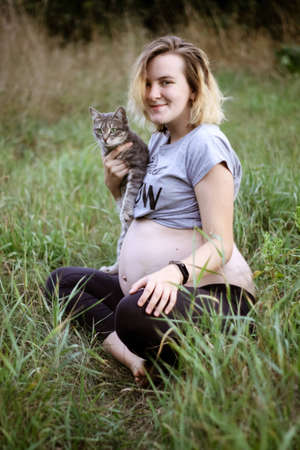 pregnant girl with a cat in her arms. carefree life. happy pregnancy.の写真素材