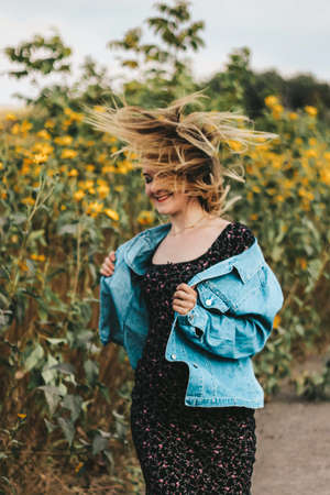 energetic, bright girl in a field of yellow flowers. bright makeup, energy.