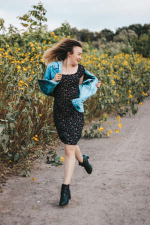 energetic, bright girl in a field of yellow flowers. bright makeup, energy.の写真素材