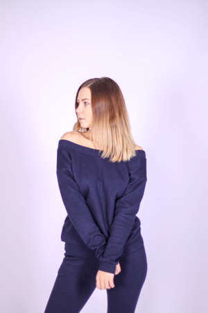 young thin girl in a knitted light suit on a black background. High quality photoの写真素材