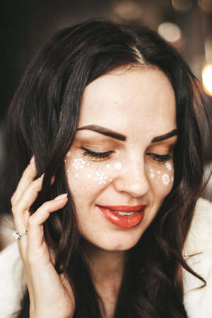 girl with New Years makeup. snowflakes on the cheeks of a girlの写真素材