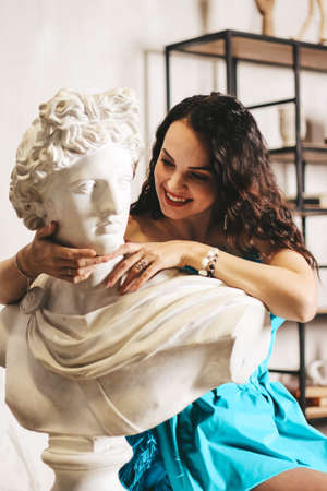 girl artist, sculptor. Vorcheskaya personality. against the background of statuettes.の写真素材