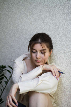 a young girl in a home setting sits in a shirt.