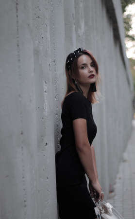 girl in a black short dress on the evening street. against the backdrop of lights, shops.の写真素材