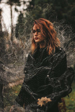 girl in a black short dress on the evening street. against the backdrop of lights, shops.の写真素材